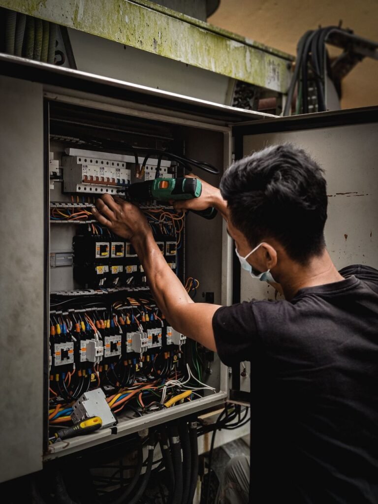 Licensed electrician adjusting a circuit breaker panel during an electrical panel upgrade in Albertville, AL