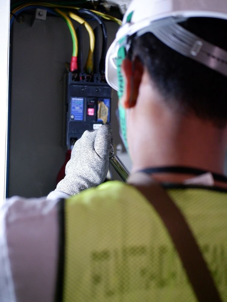 Licensed electrician working on a circuit breaker panel during an electrical panel upgrade in Dadeville, AL