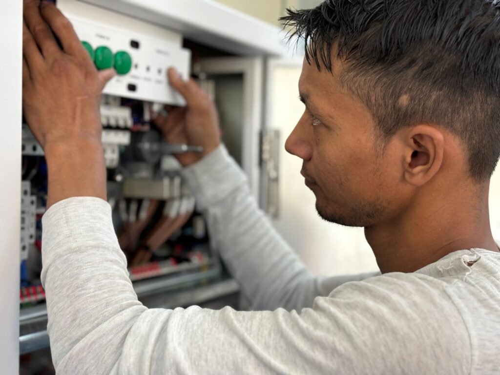 Licensed electrician adjusting a circuit breaker panel during an electrical panel upgrade in Montevallo, AL