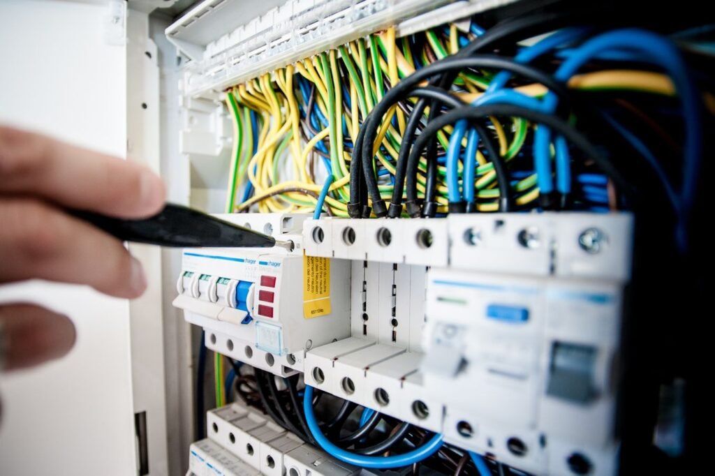 Electrician working inside an opened switchboard during a 200 amp panel upgrade in Brookwood, AL