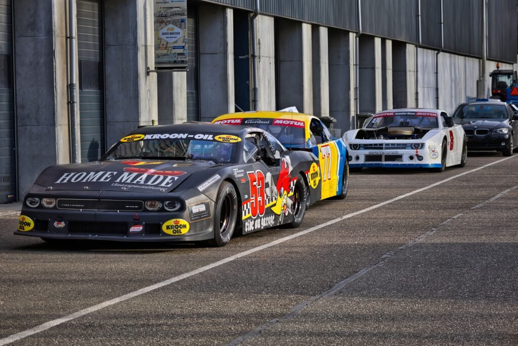 Stock cars in a racing garage, similar to the Alabama Gang NASCAR teams from Hueytown, AL